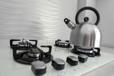 Photo of Kettle on modern gas stove in kitchen