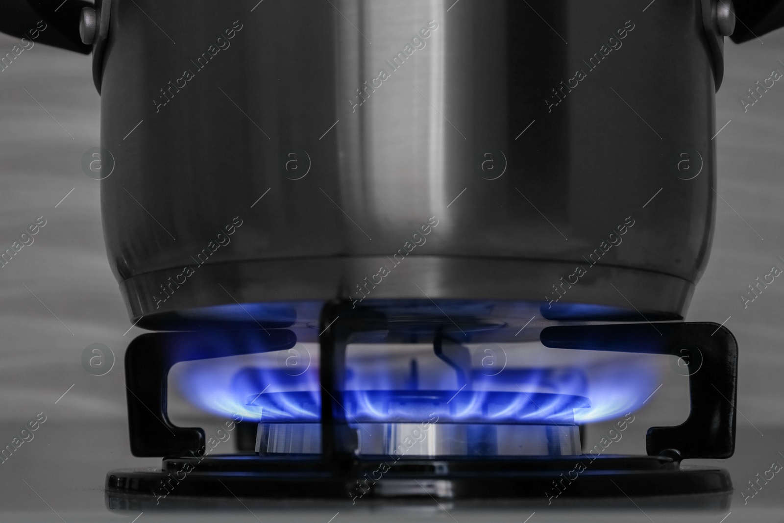 Photo of Pot on modern gas cooktop in kitchen, closeup