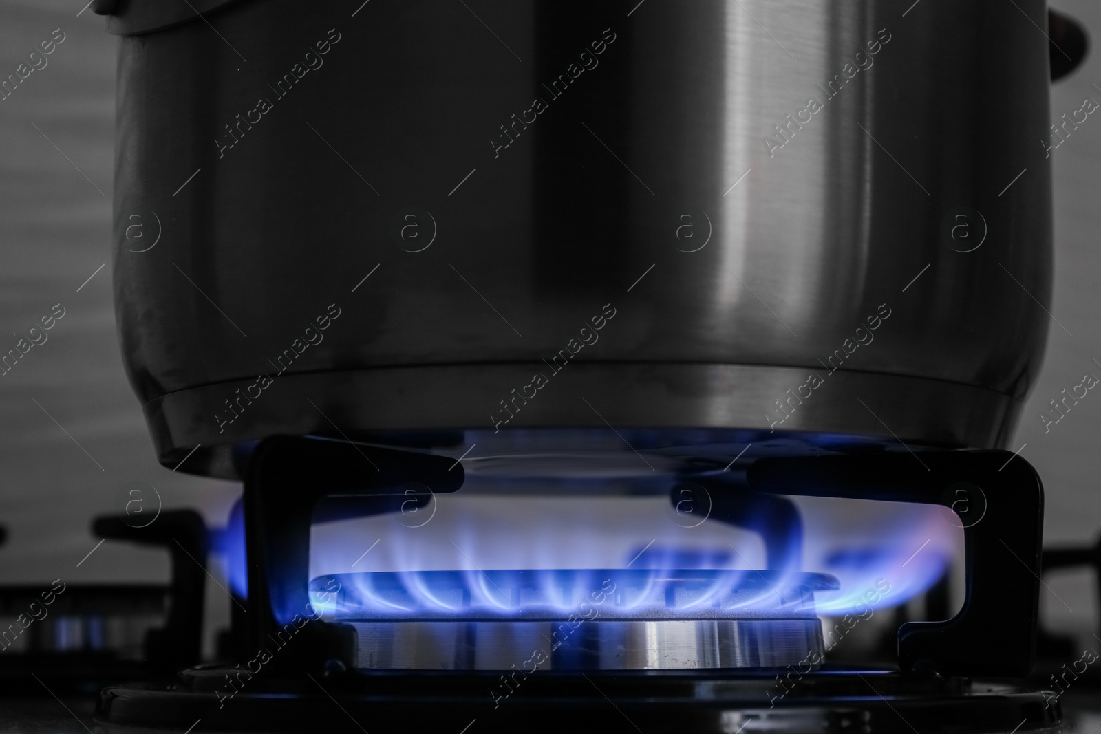 Photo of Pot on modern gas cooktop in kitchen, closeup