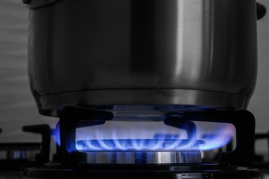 Photo of Pot on modern gas cooktop in kitchen, closeup