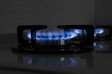 Photo of Gas burner of modern stove with burning blue flame