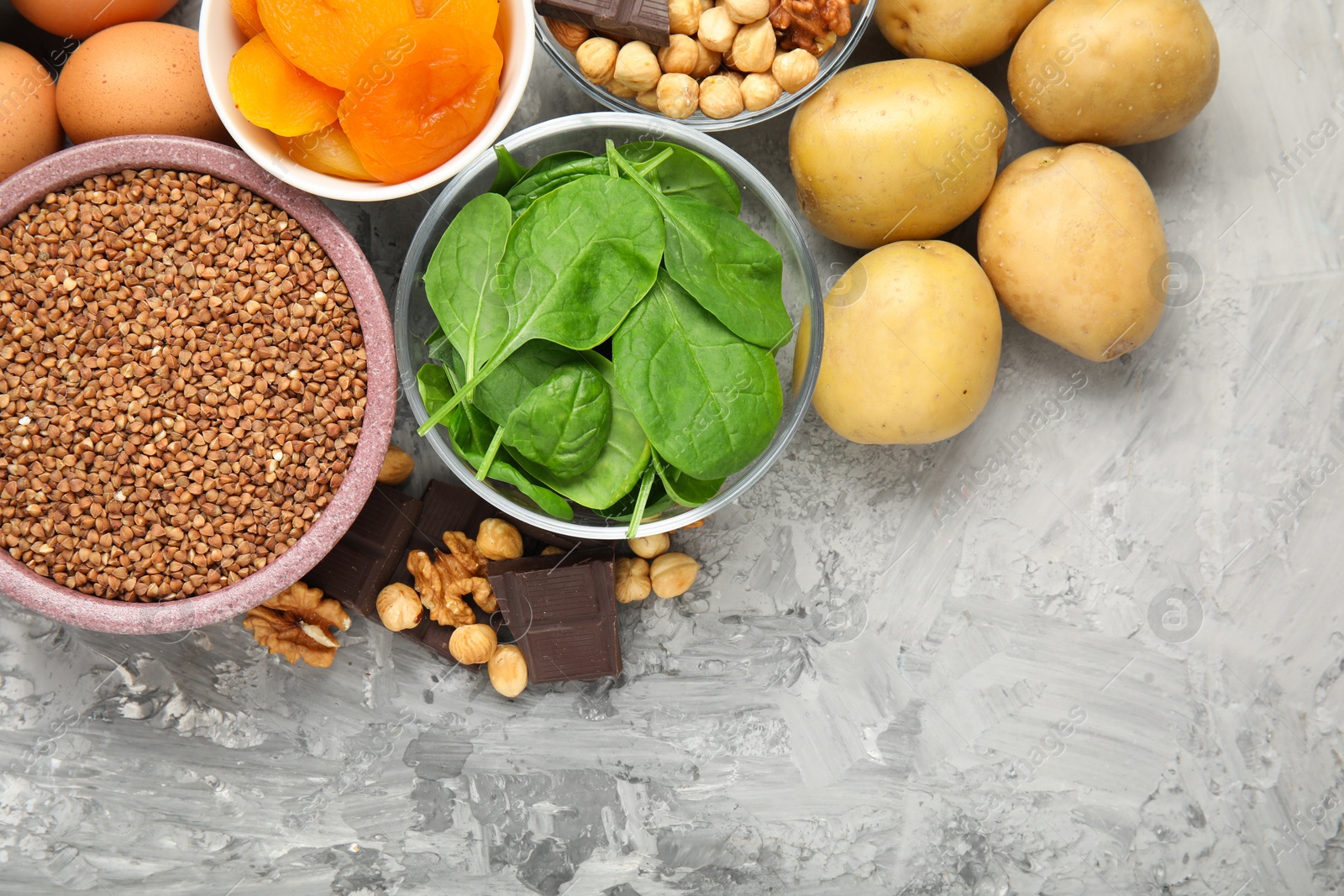 Photo of Different products rich in iron on grey table, flat lay. Diet plan for anemia