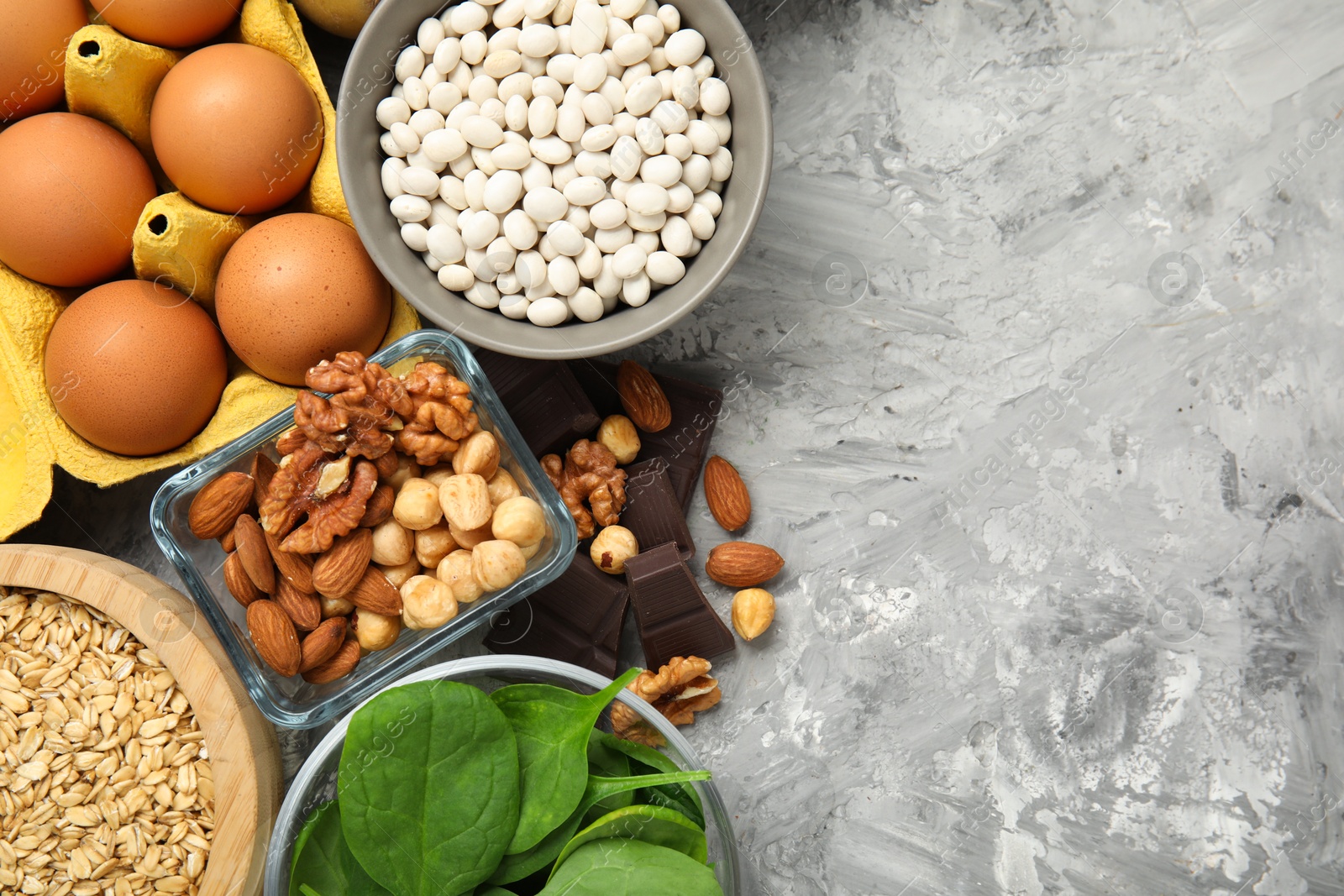 Photo of Diet plan for anemia. Different products rich in iron on grey table, flat lay. Space for text