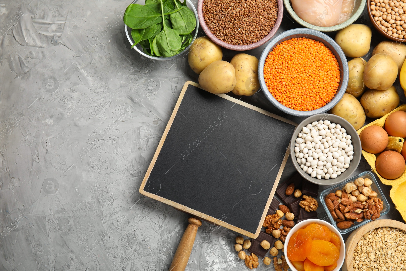 Photo of Diet plan for anemia. Different products rich in iron and small chalkboard on grey table, flat lay. Space for text