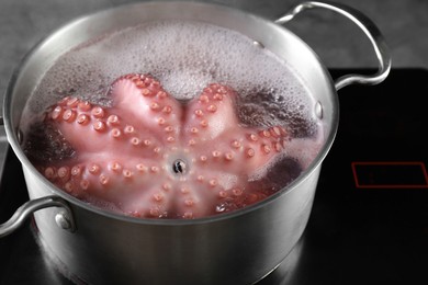 Photo of Fresh octopus boiling in pan on stove, closeup