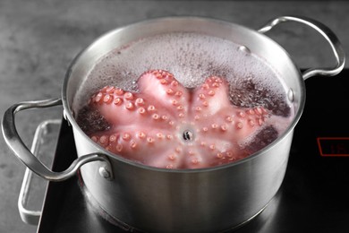 Photo of Fresh octopus boiling in pan on stove, closeup