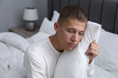 Photo of Young man suffering from sleepwalking on bed at home