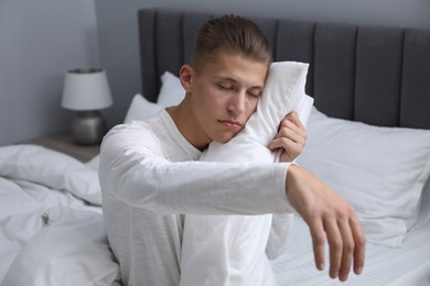 Photo of Young man suffering from sleepwalking on bed at home