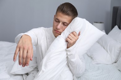 Photo of Young man suffering from sleepwalking on bed at home