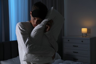 Photo of Young man suffering from sleepwalking at home, space for text