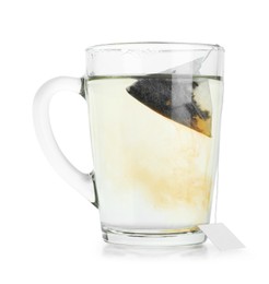 Photo of Tea bag in glass cup with hot drink isolated on white