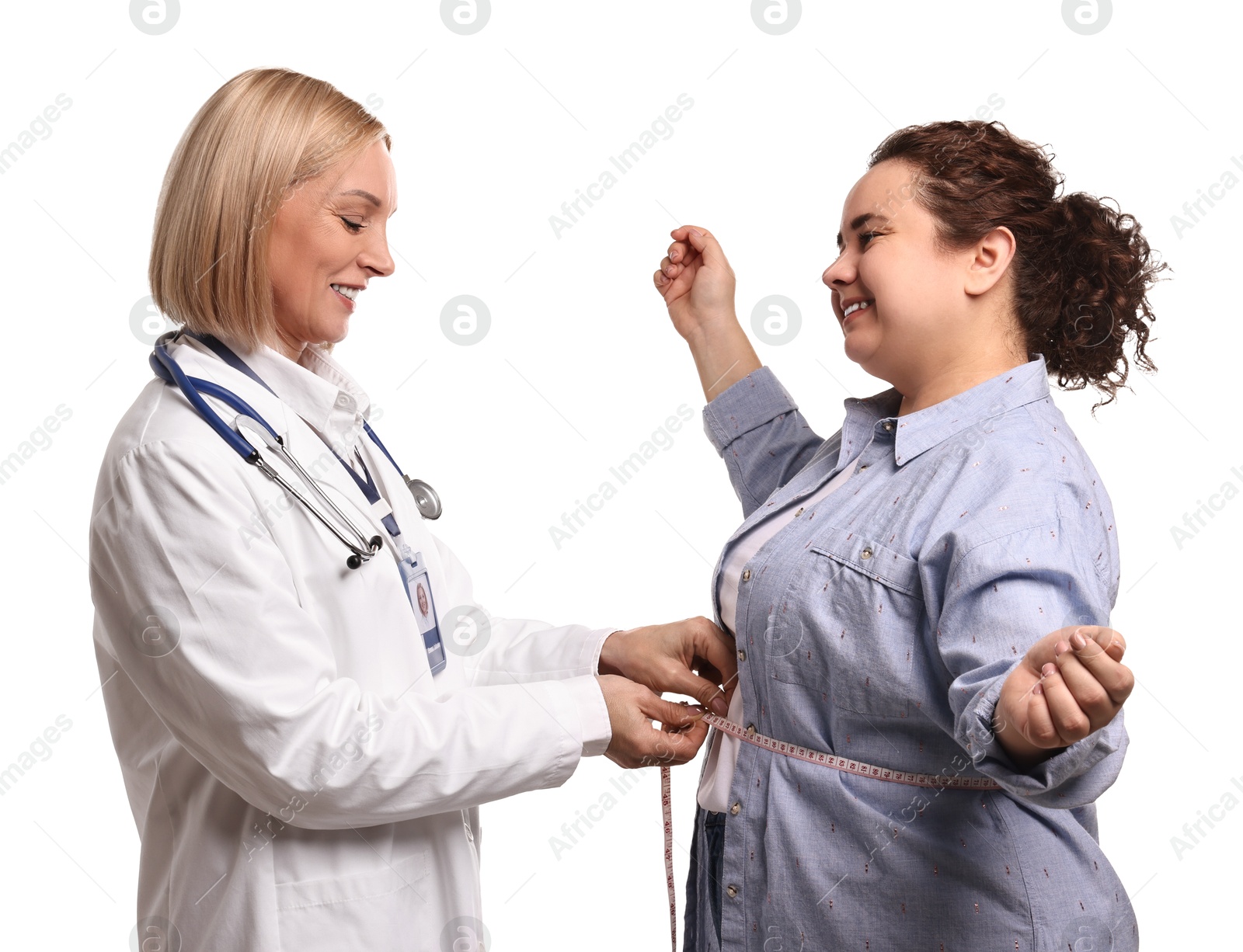 Photo of Happy woman lost weight. Smiling nutritionist measuring patient's waist with tape on white background