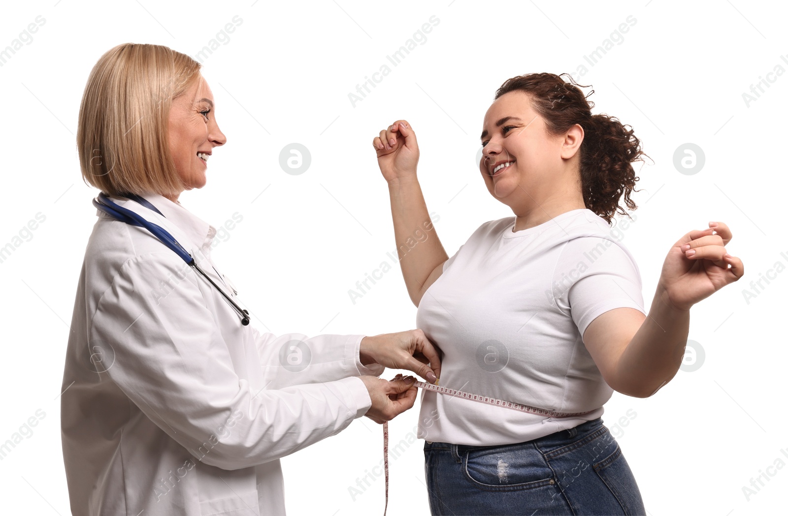 Photo of Happy woman lost weight. Smiling nutritionist measuring patient's waist with tape on white background