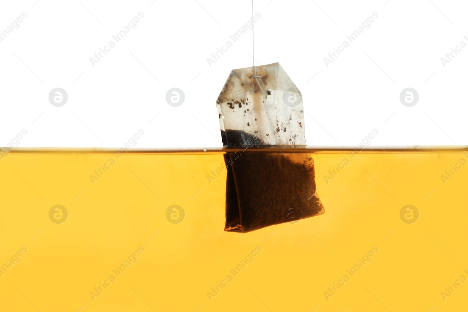 Photo of Putting tea bag into glass cup on white background, closeup