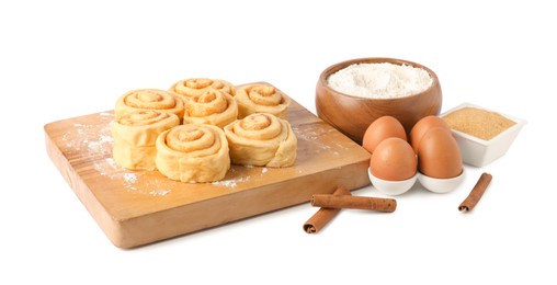 Photo of Raw cinnamon rolls and different ingredients isolated on white