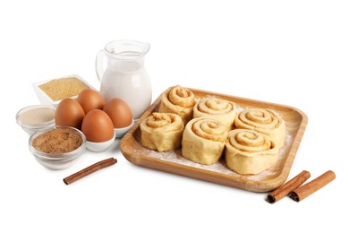 Photo of Raw cinnamon rolls and different ingredients isolated on white