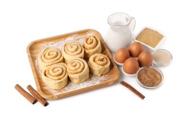 Photo of Raw cinnamon rolls and different ingredients isolated on white