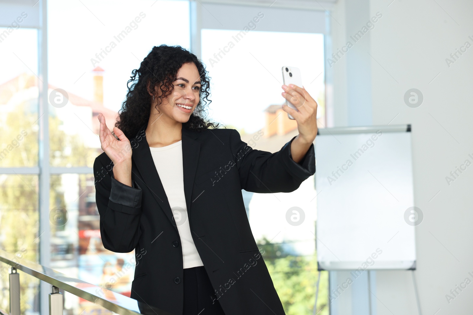 Photo of Portrait of young woman with phone wearing stylish suit indoors