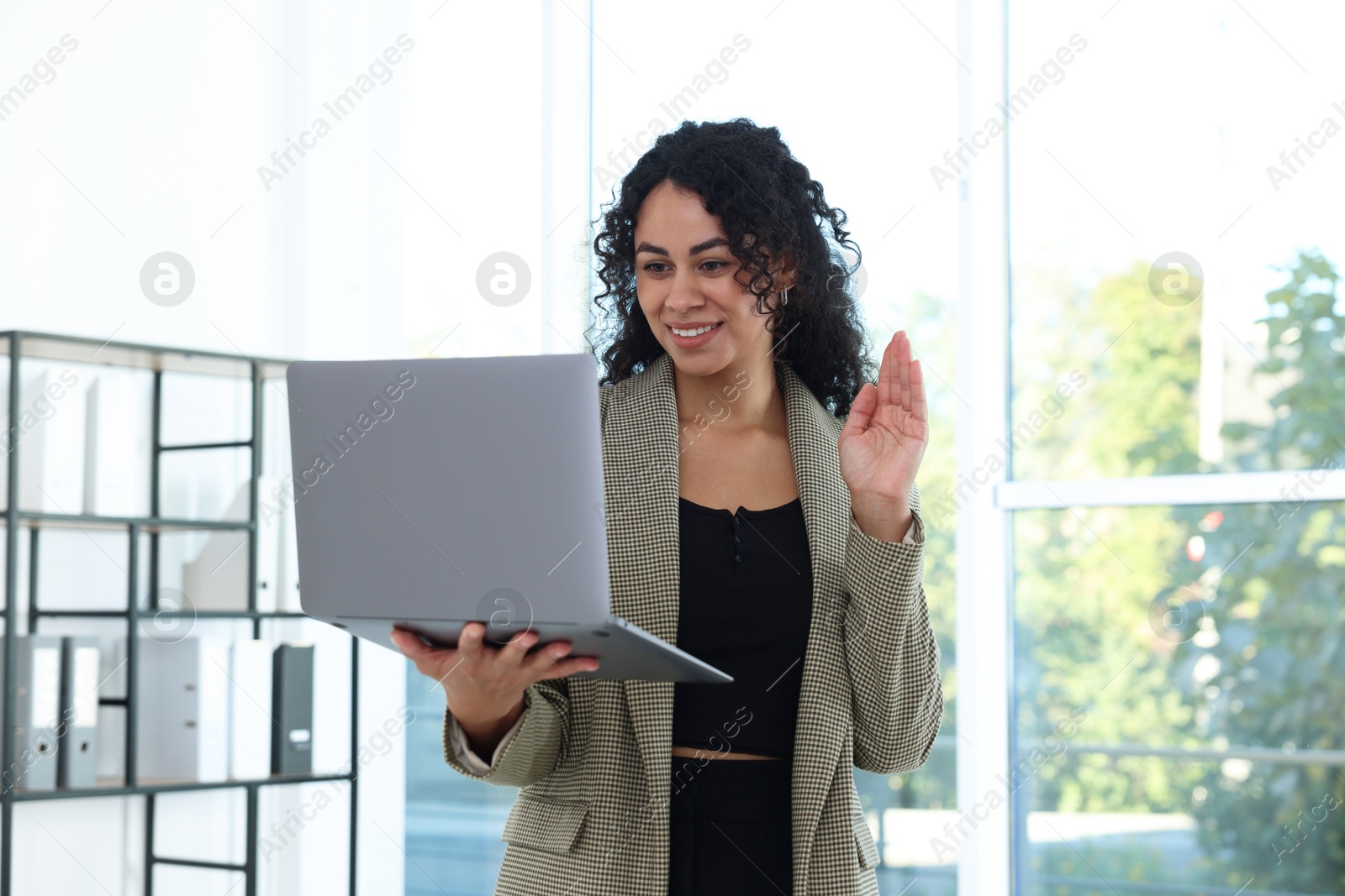 Photo of Portrait of young woman with laptop wearing stylish suit indoors