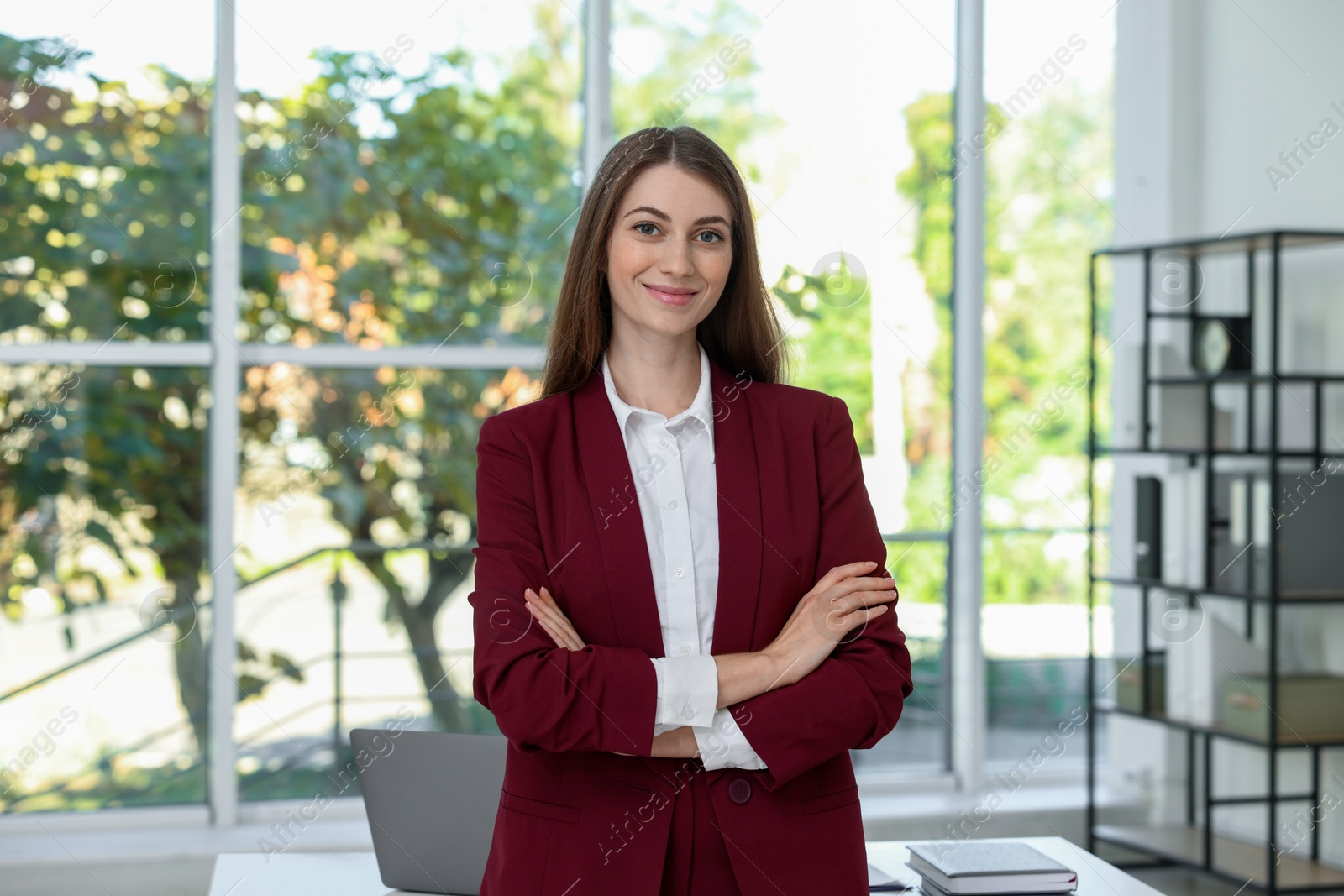 Photo of Portrait of young woman with laptop wearing stylish suit indoors