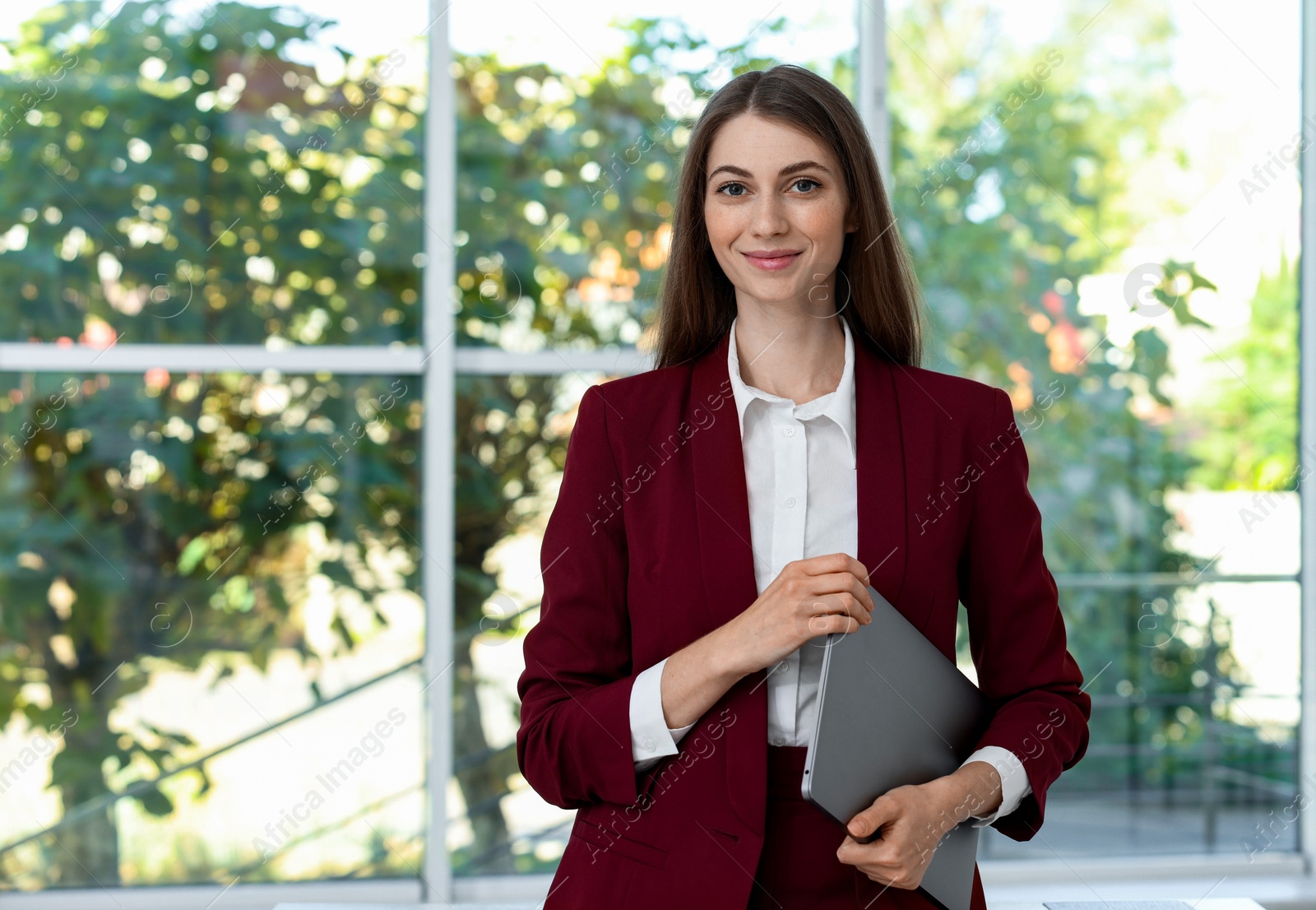 Photo of Portrait of young woman with book wearing stylish suit indoors