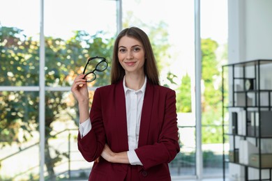 Portrait of young woman wearing stylish suit indoors