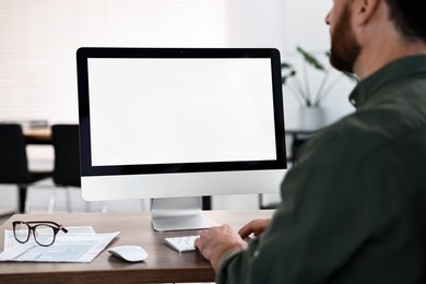 Photo of Man working on computer at table in office, closeup