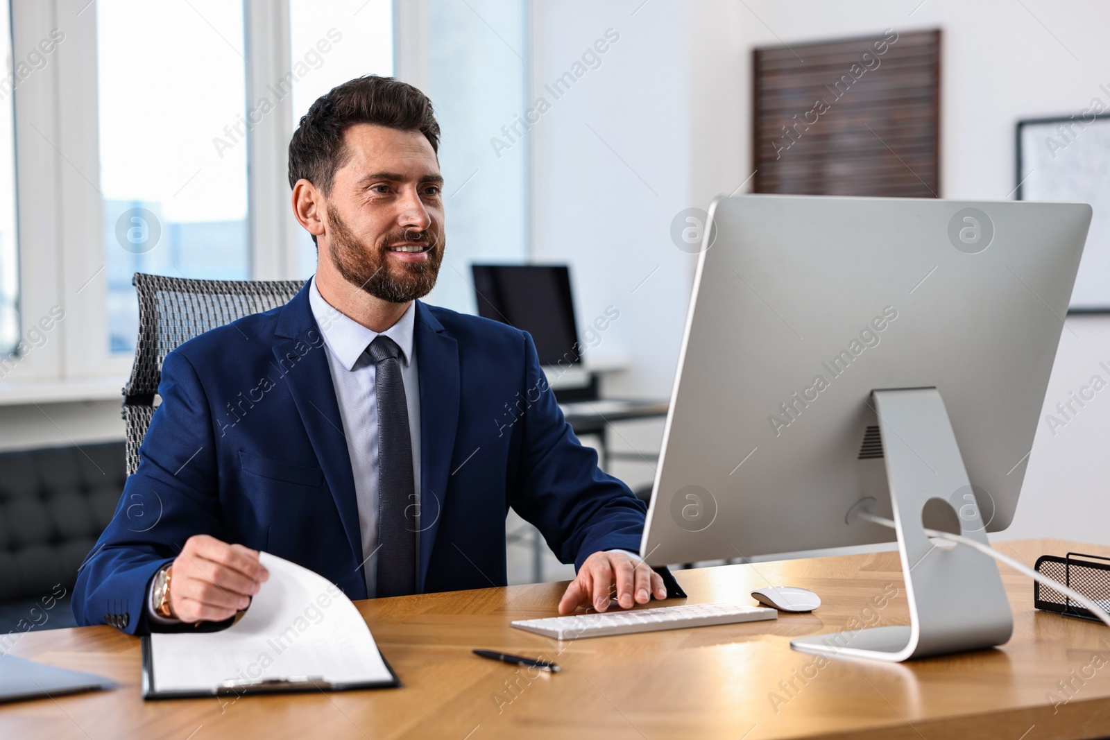 Photo of Man working on computer at table in office