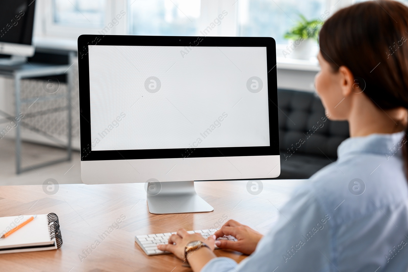 Photo of Woman working on computer at table in office