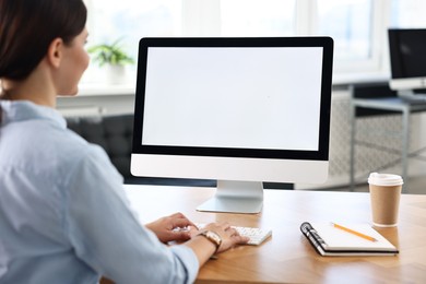 Photo of Woman working on computer at table in office