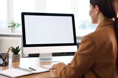 Photo of Woman working on computer at table in office