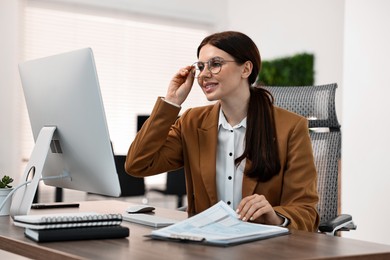 Photo of Woman working with computer at table in office