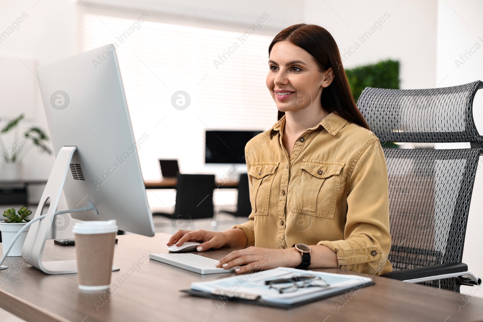 Photo of Woman working on computer at table in office