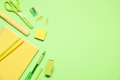 Photo of Different stationery on green background, flat lay. Space for text