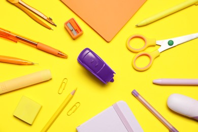 Photo of Different stationery on yellow background, flat lay