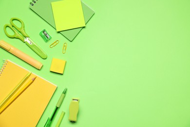 Photo of Different stationery on green background, flat lay. Space for text