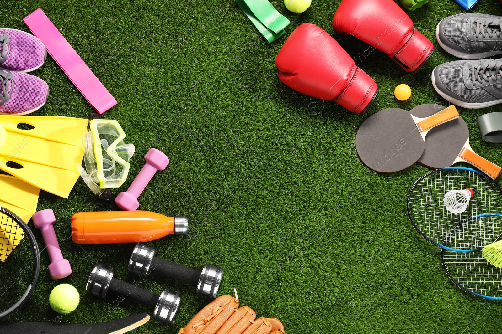 Photo of Different sport equipment on artificial grass, flat lay. Space for text