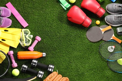 Photo of Different sport equipment on artificial grass, flat lay. Space for text