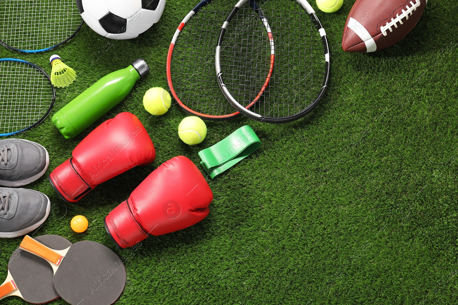 Photo of Different sport equipment on artificial grass, flat lay. Space for text