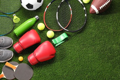 Photo of Different sport equipment on artificial grass, flat lay. Space for text