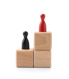 Photo of Human figures on wooden blocks, red one on top against white background. Competition concept