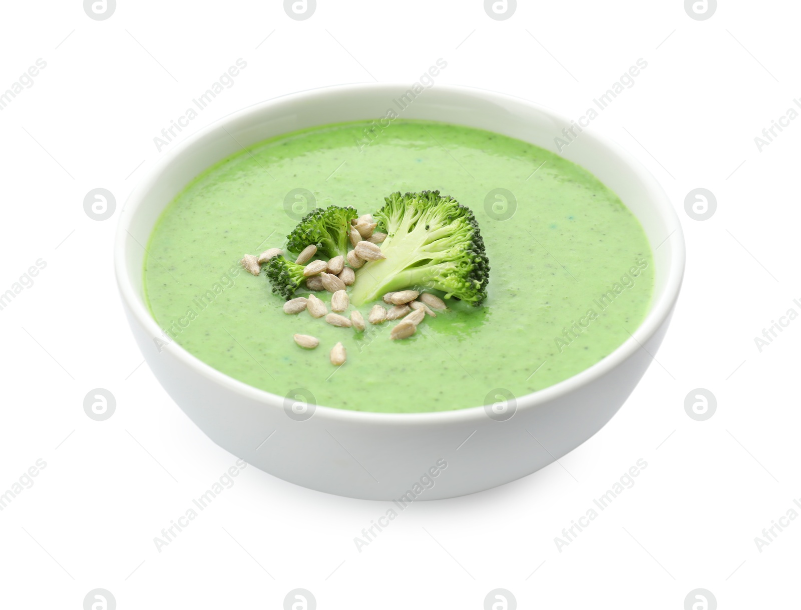 Photo of Delicious broccoli cream soup with sunflower seeds in bowl isolated on white