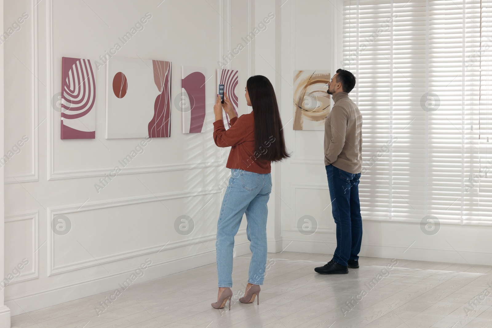 Photo of Woman taking photo of painting in art gallery