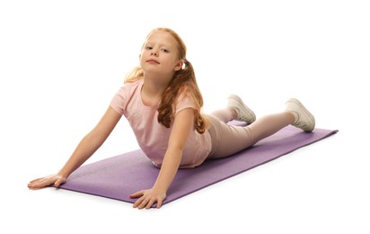 Cute little girl on fitness mat against white background