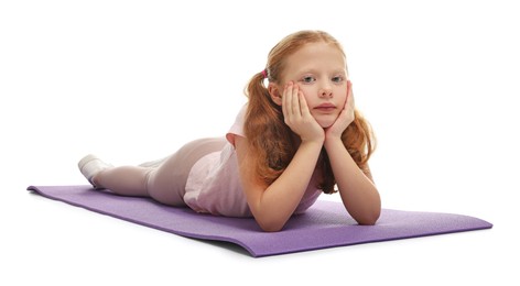 Photo of Cute little girl on fitness mat against white background