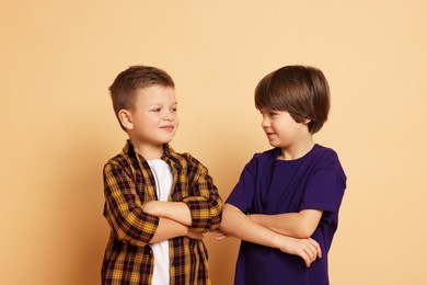 Portrait of cute brothers on beige background