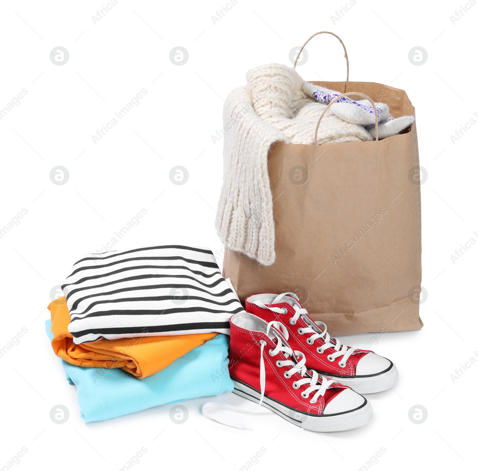 Photo of Bag with used clothes and sneakers isolated on white