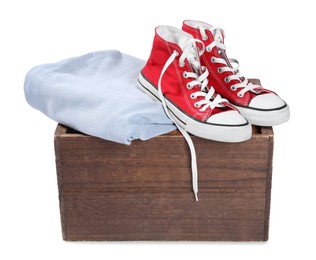 Crate with used clothes and shoes isolated on white