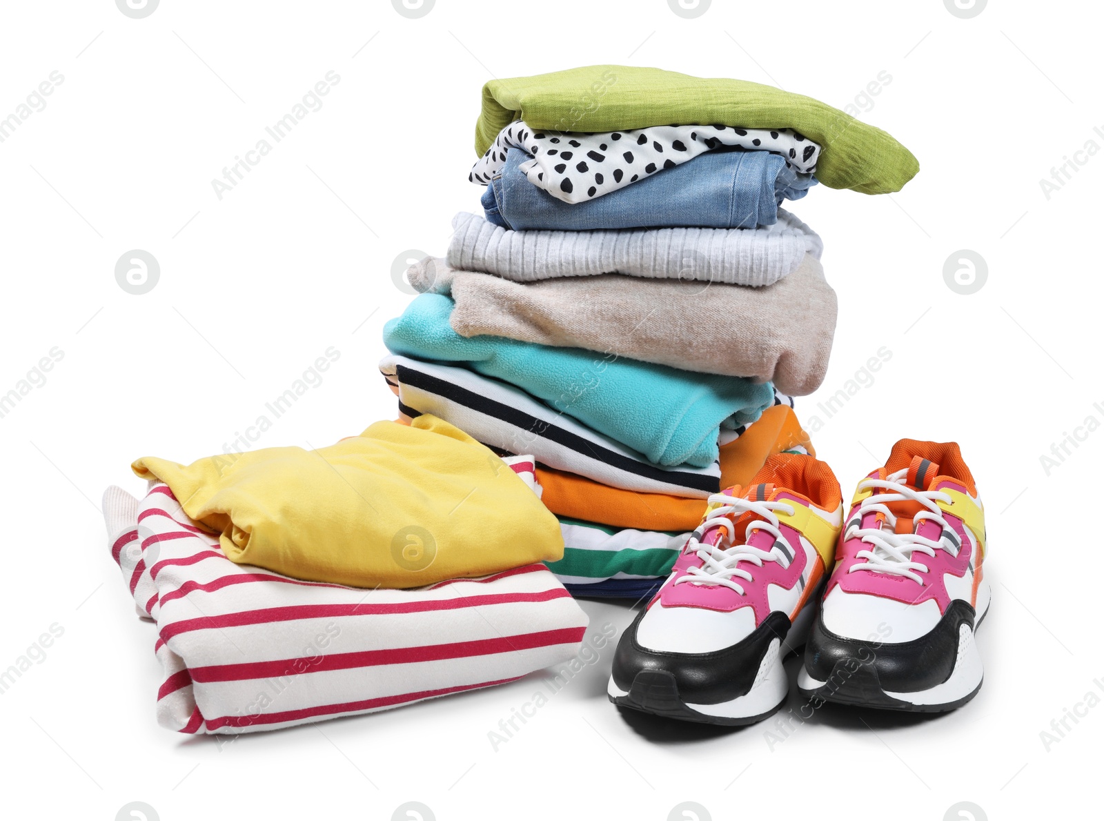 Photo of Stack of used clothes and sneakers isolated on white