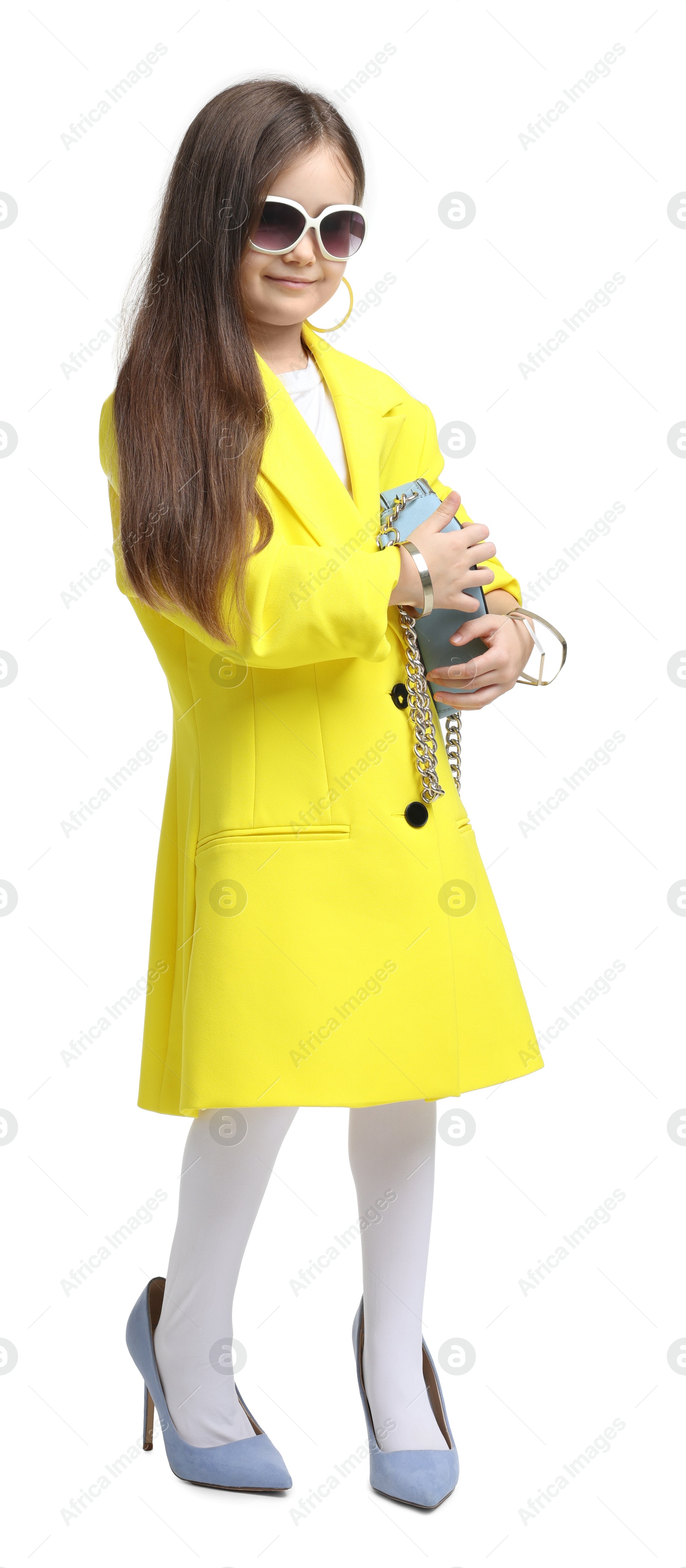 Photo of Stylish little girl wearing oversized high heeled shoes on white background